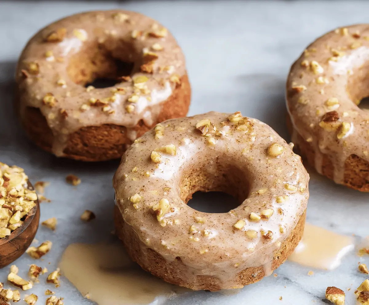 Delicious baked apple donuts glazed with shiny frosting on a plate, perfect for a sweet breakfast or snack