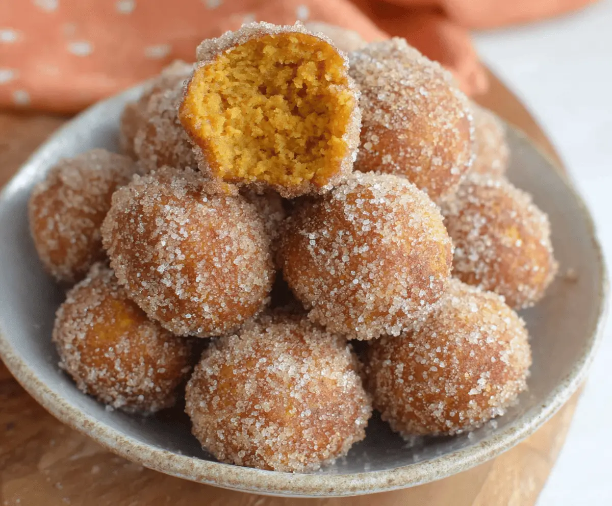 Delicious homemade Easy Bisquick Pumpkin Donut Holes on a white plate with cinnamon sugar coating, perfect for fall treats