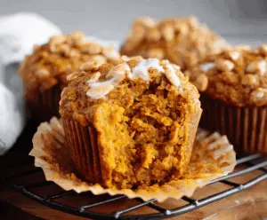 Delicious and healthy pumpkin muffins with cinnamon and walnuts on a white plate, perfect for a nutritious snack or breakfast.
