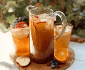 Refreshing Sweet Tea Harvest Punch in a glass pitcher with fresh fruit garnishes, perfect for summer gatherings