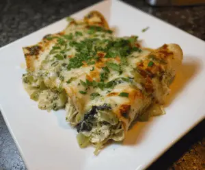 Delicious spinach and artichoke chicken enchiladas served on a plate with melted cheese and fresh herbs.