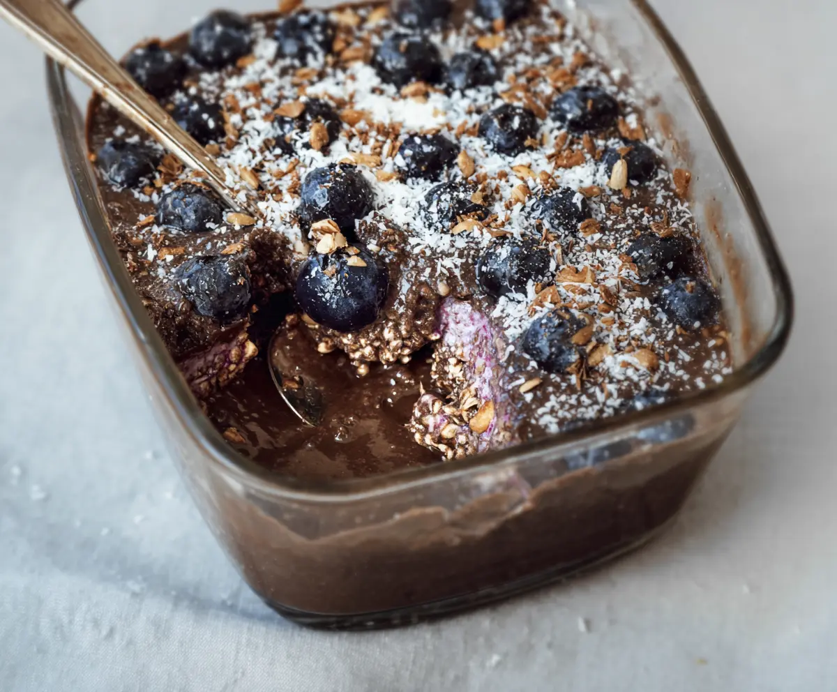 Healthy chocolate coconut blueberry overnight Weetbix breakfast in a glass bowl.