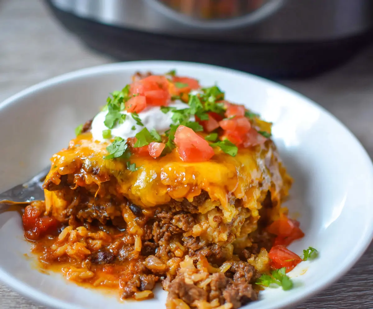 Delicious Crockpot Beef Enchilada Casserole in a serving dish, topped with cheese and fresh herbs.