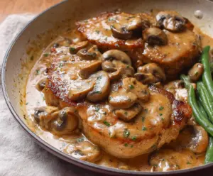 Delicious pork chops topped with a savory garlic mushroom sauce on a rustic plate.