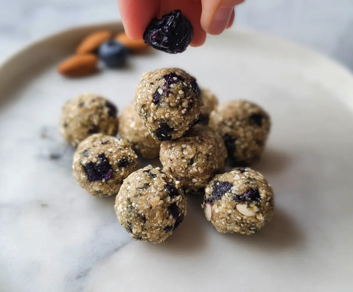 Healthy Blueberry Almond Energy Bites on a white plate, showcasing fresh blueberries and crunchy almonds.