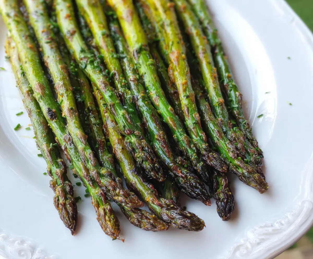 Garam Masala Grilled Asparagus on a plate with spices and herbs, healthy vegetarian dish.