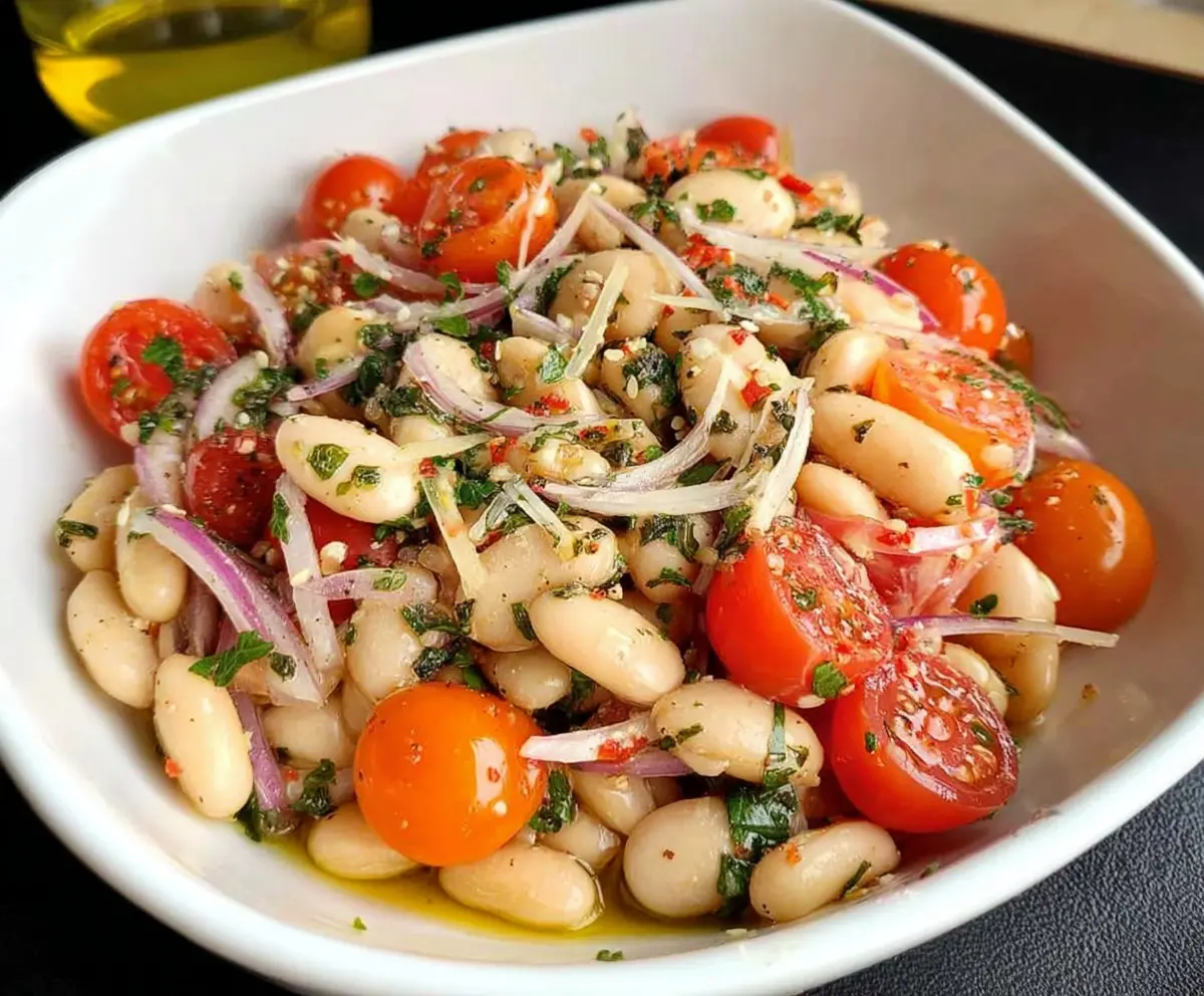 Fresh Italian White Bean Salad with cherry tomatoes, basil, and olive oil on a rustic plate.