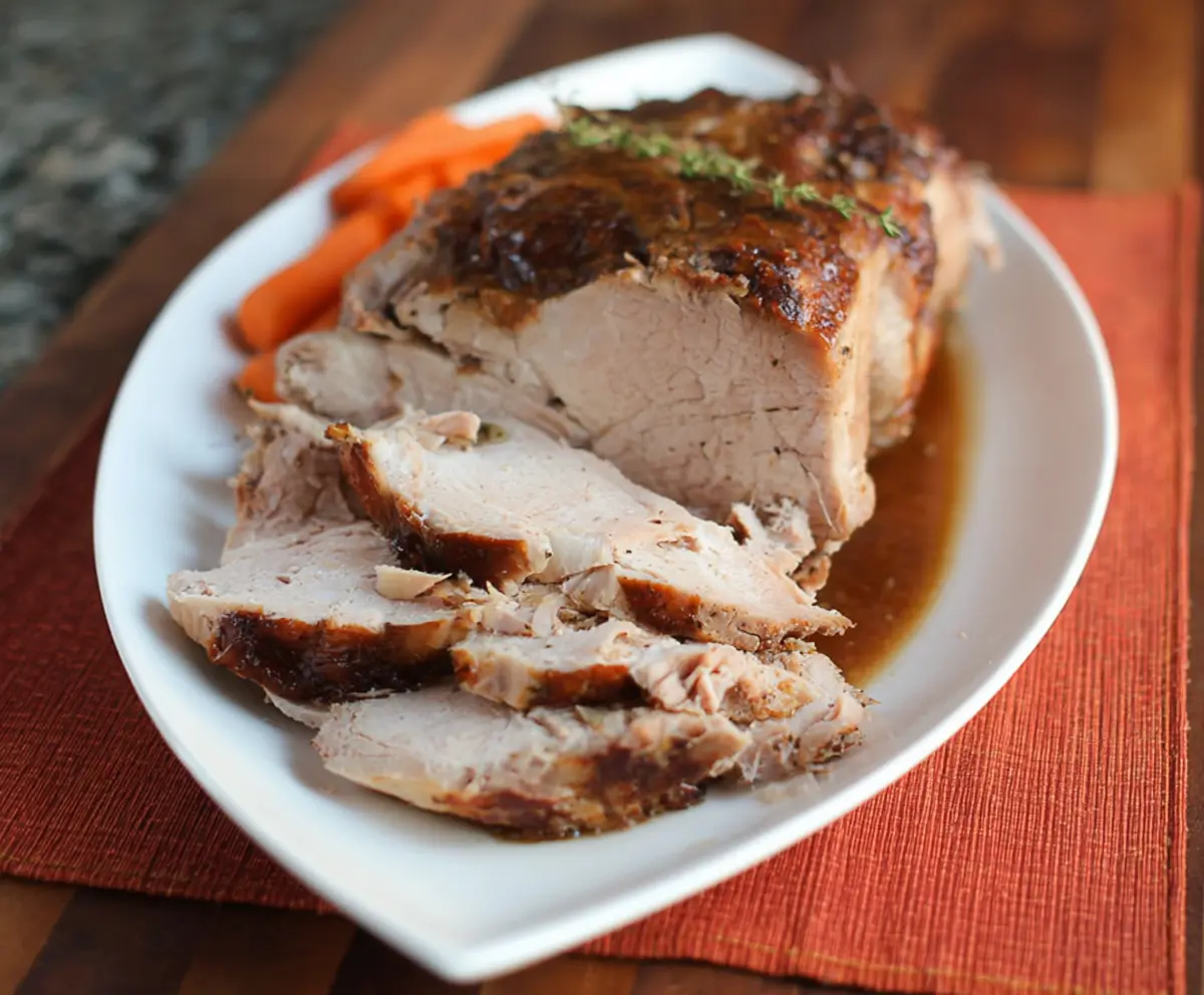 Juicy pressure cooker pork roast with crispy edges served on a wooden platter.